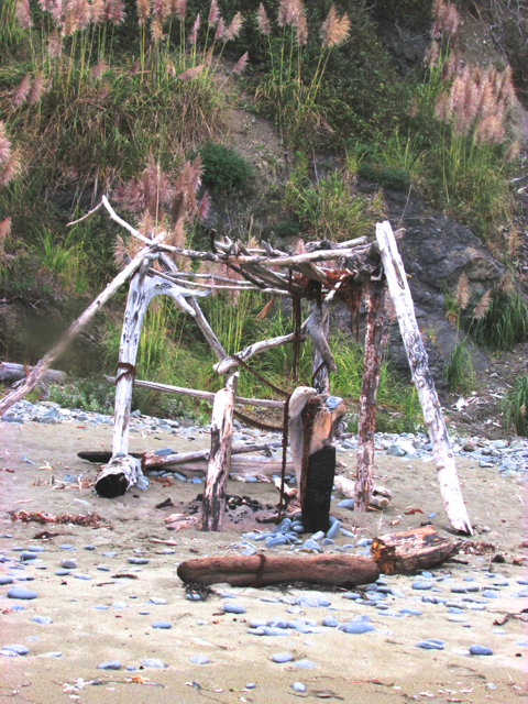 A structure made of driftwood and seaweed.